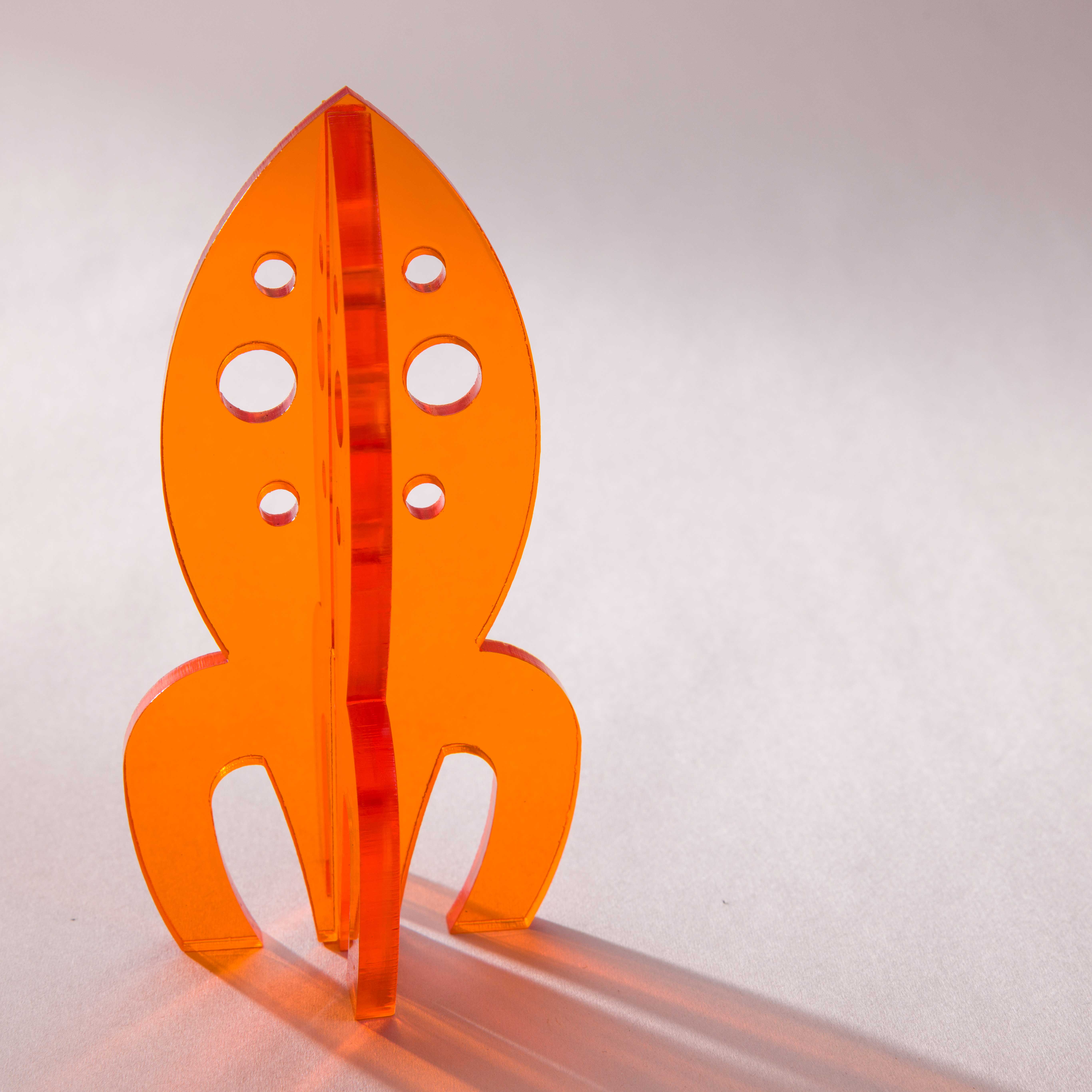 Orange laser-cut acrylic rocket desk toy